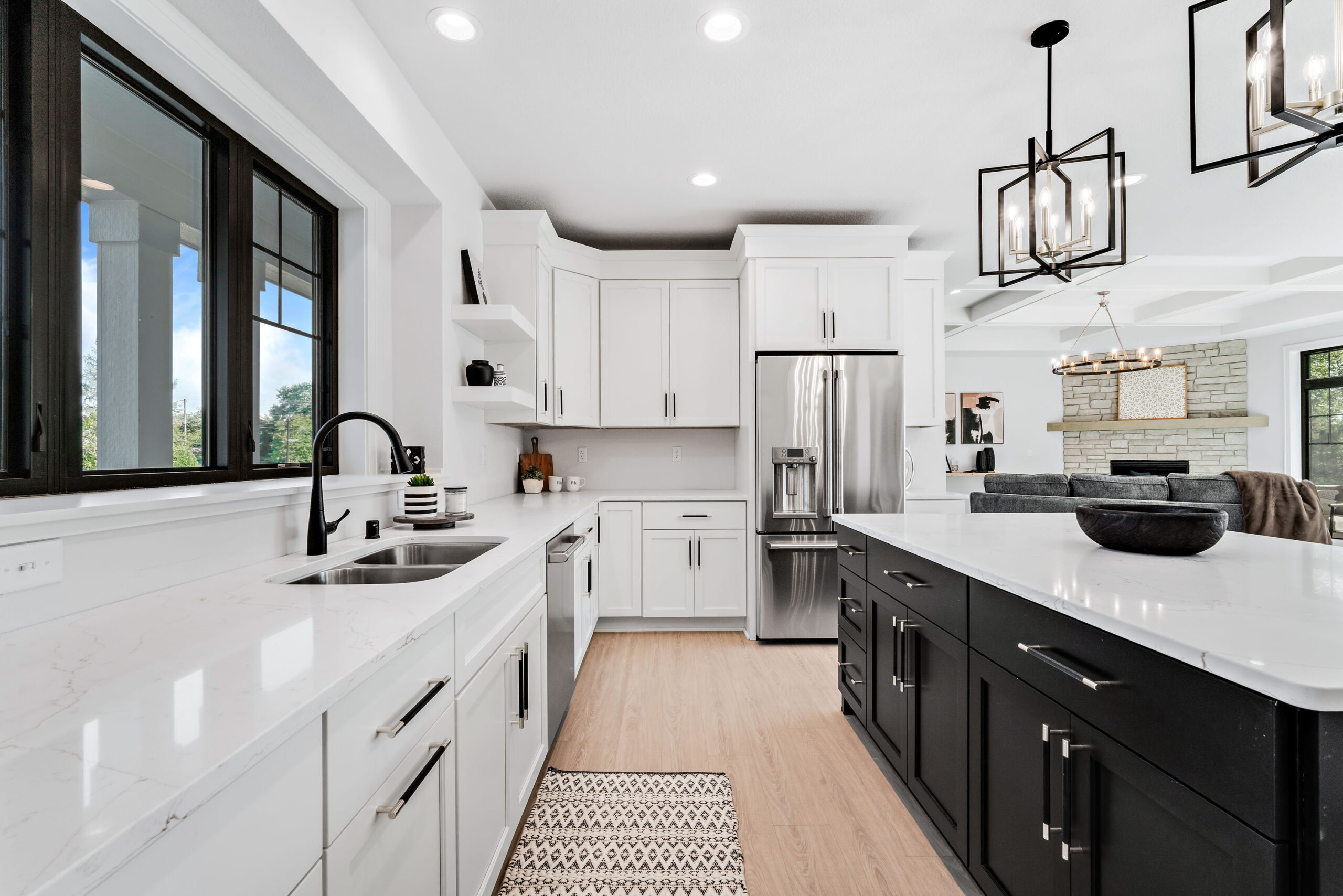 Modern kitchen with large island seating, white cabinetry, black island, and stainless steel appliances