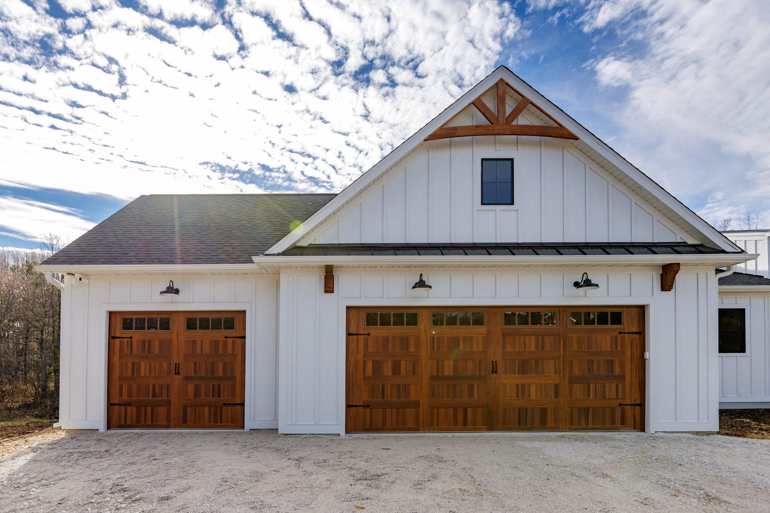 Exterior of Merton home with white siding and custom wood garage doors
