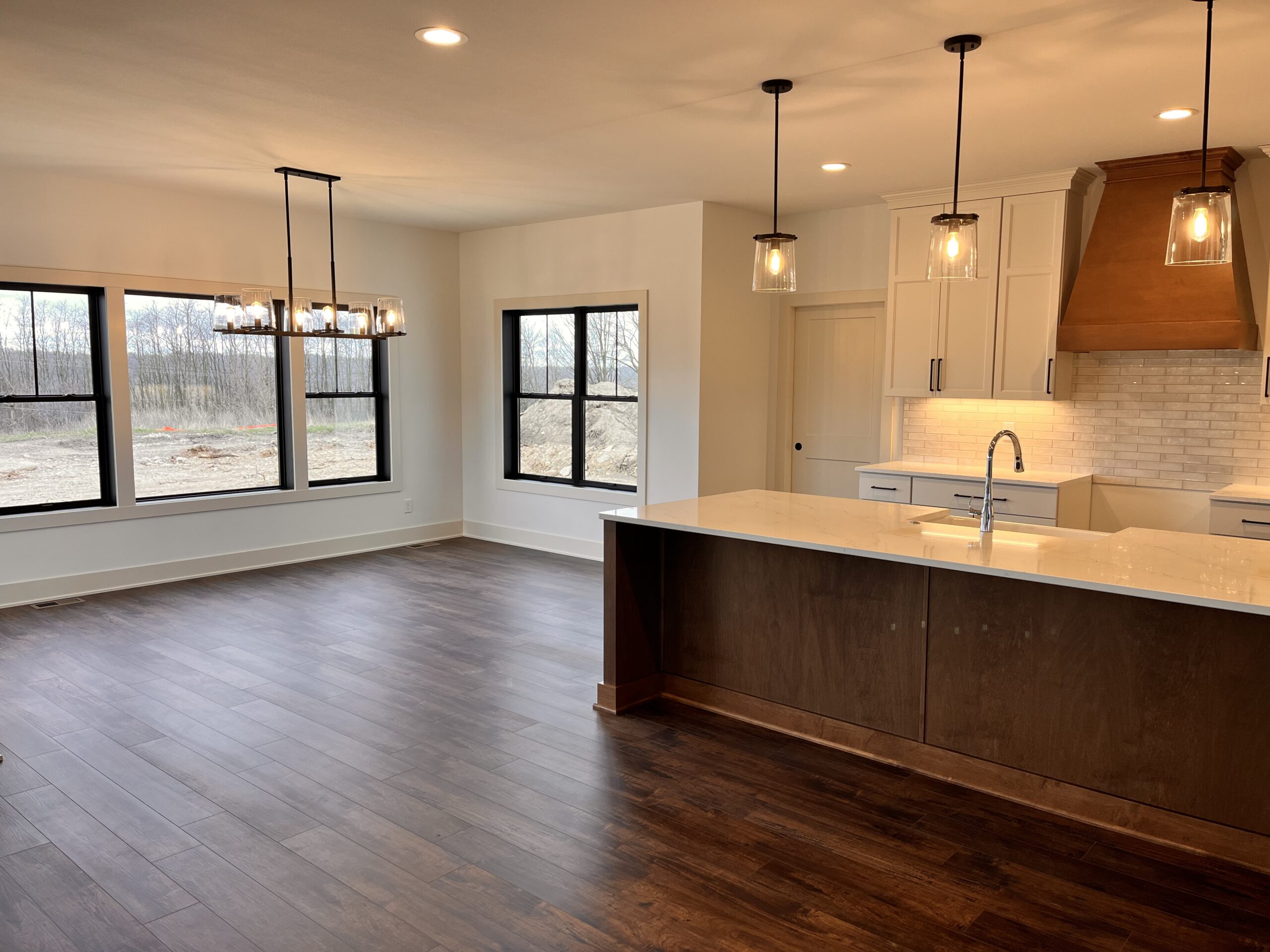 Yaun Home open concept kitchen and dining area with wood island, quartz countertops, and large windows