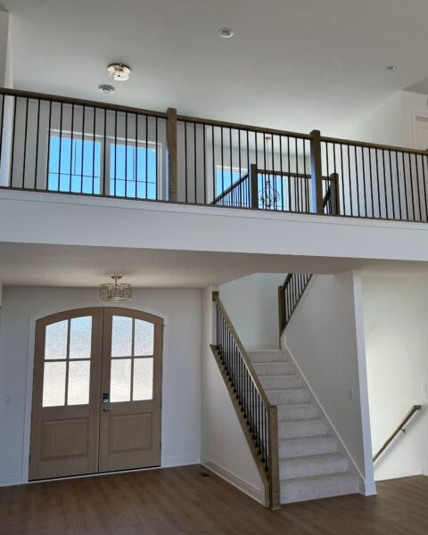 Morrow Home entryway with staircase, wood railing, and second floor overlook